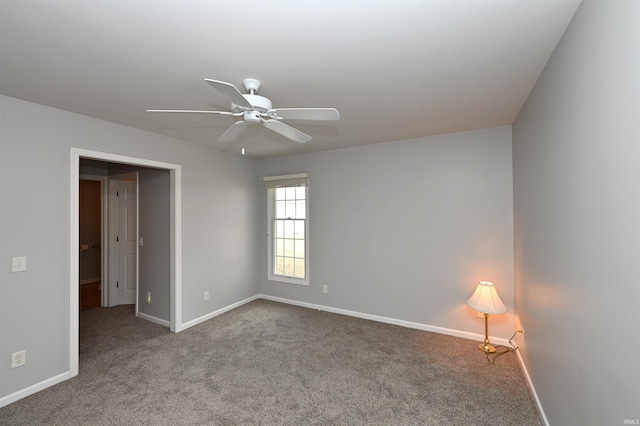 carpeted spare room with baseboards and a ceiling fan