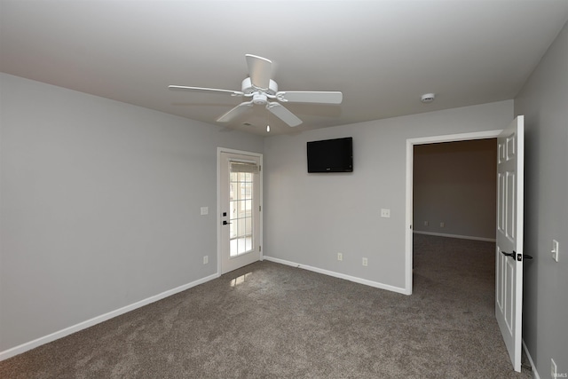 unfurnished room with baseboards, dark carpet, and ceiling fan