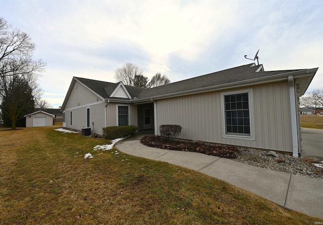 ranch-style home with a front yard and an outbuilding