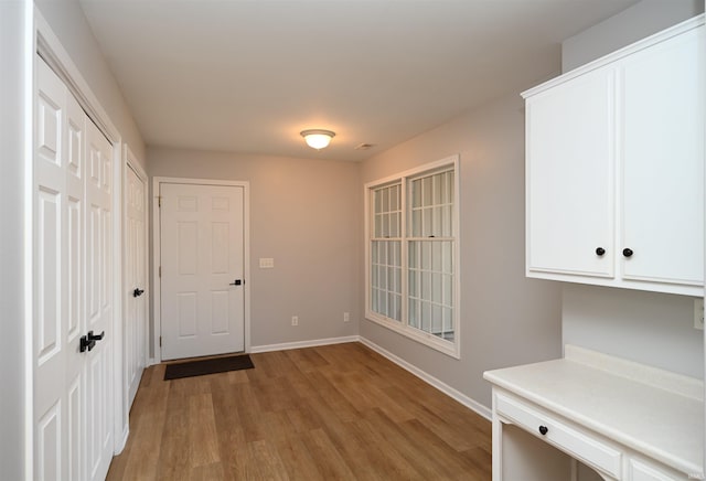 interior space featuring light wood-style flooring and baseboards