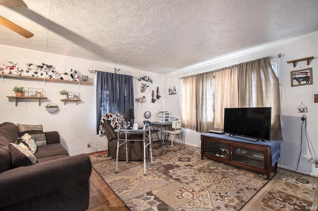 living area featuring ceiling fan and a textured ceiling