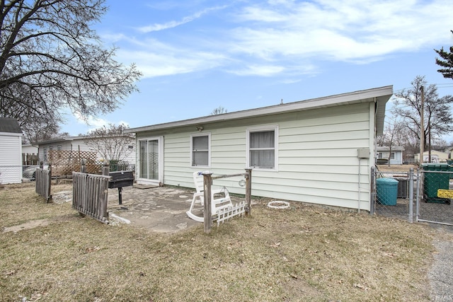 rear view of house featuring a yard, a patio area, and fence