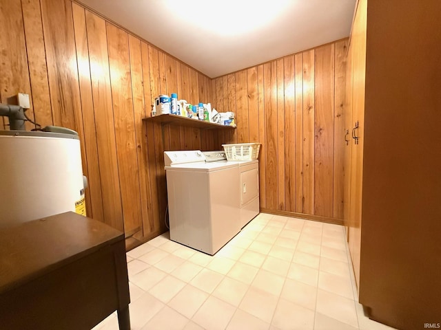 washroom with gas water heater, independent washer and dryer, wooden walls, and laundry area