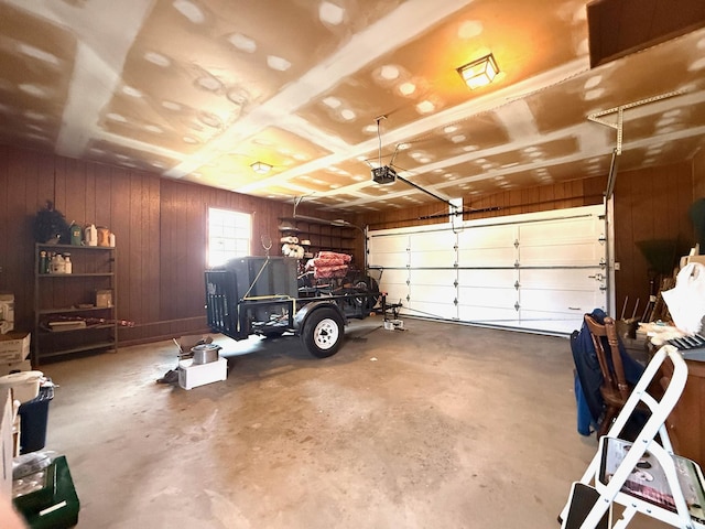 garage featuring a garage door opener and wooden walls