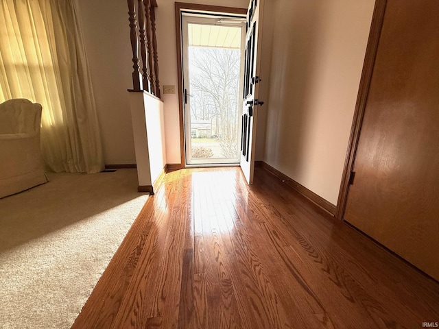 doorway to outside with baseboards and wood finished floors