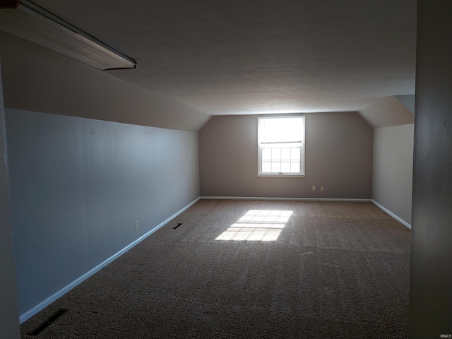 additional living space with lofted ceiling, carpet, and baseboards