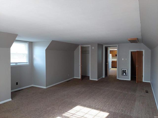 additional living space featuring carpet floors, vaulted ceiling, and baseboards