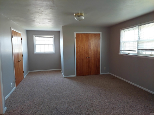 unfurnished bedroom featuring light colored carpet and baseboards