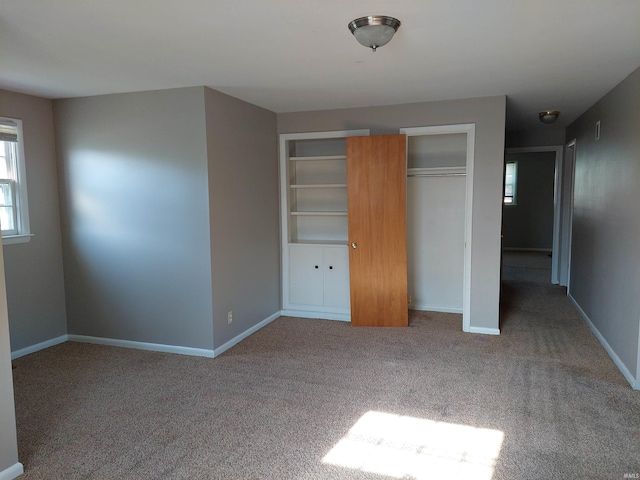 unfurnished bedroom featuring light carpet and baseboards