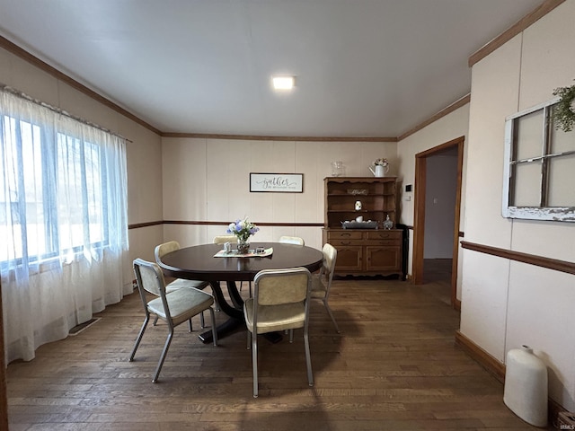 dining room featuring dark wood finished floors, visible vents, and crown molding