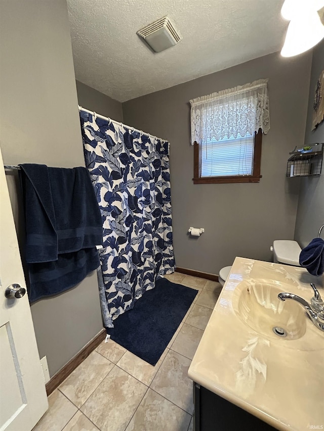 full bath featuring visible vents, a shower with shower curtain, a textured ceiling, baseboards, and tile patterned floors