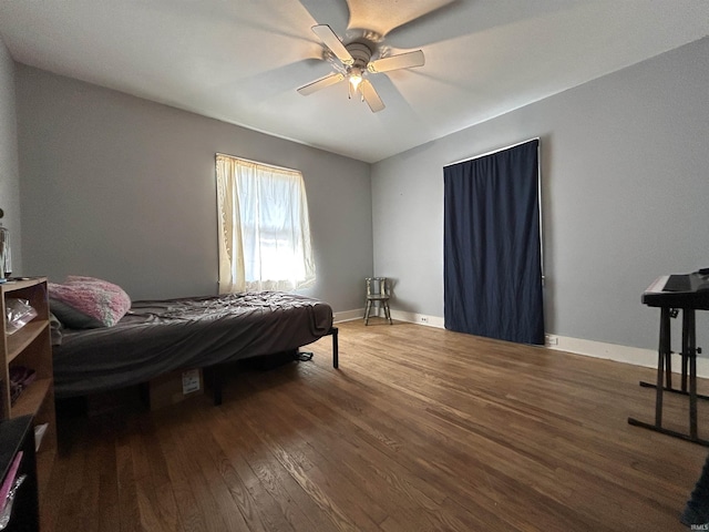 bedroom featuring ceiling fan, wood finished floors, and baseboards