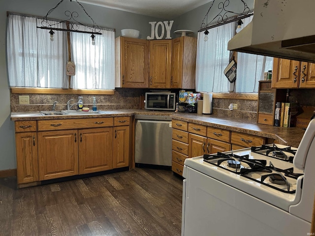 kitchen with white gas stove, under cabinet range hood, dark wood-style floors, a sink, and dishwasher