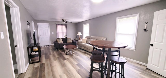 dining space featuring ceiling fan, wood finished floors, and baseboards