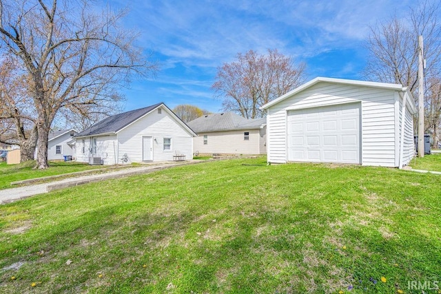 view of yard featuring central AC unit, an outbuilding, and a detached garage