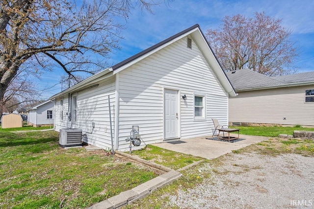 exterior space with a patio area, a lawn, and cooling unit