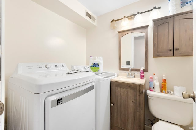 clothes washing area featuring laundry area, independent washer and dryer, a sink, and visible vents