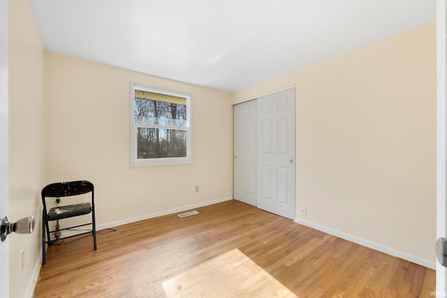 interior space featuring light wood-style floors, visible vents, and baseboards