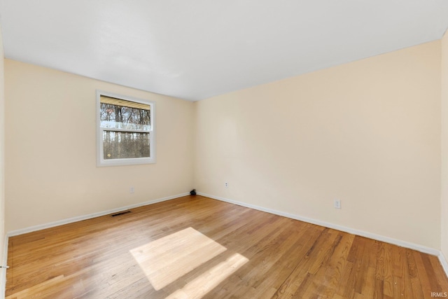 unfurnished room with baseboards, visible vents, and light wood-style floors