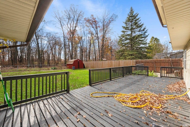 deck with a storage unit, a lawn, an outdoor structure, and a fenced backyard