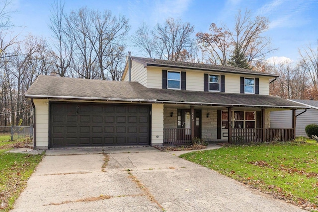 traditional-style house featuring driveway, a shingled roof, an attached garage, a porch, and a front yard