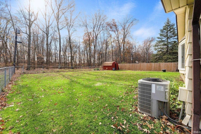 view of yard featuring a storage unit, a fenced backyard, an outdoor structure, and cooling unit