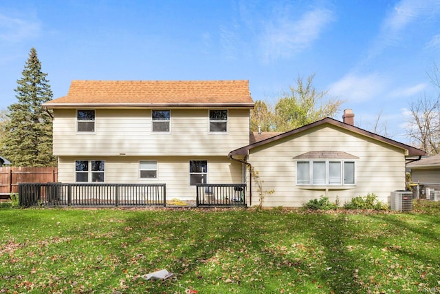 rear view of house featuring central AC, a lawn, a wooden deck, and fence