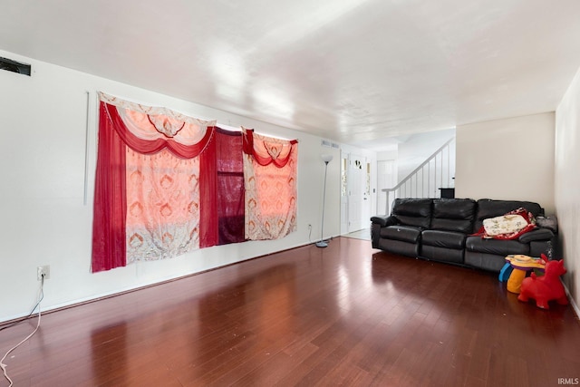 living room with stairway, wood finished floors, and visible vents