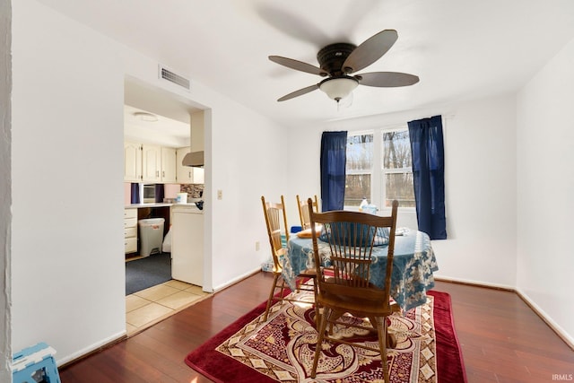 dining room featuring baseboards, visible vents, and light wood finished floors