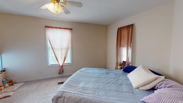 bedroom featuring a ceiling fan, baseboards, visible vents, and carpet flooring