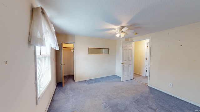 unfurnished bedroom featuring baseboards, ceiling fan, carpet, a textured ceiling, and a closet