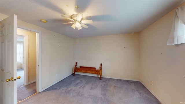 unfurnished room featuring light colored carpet, ceiling fan, and baseboards