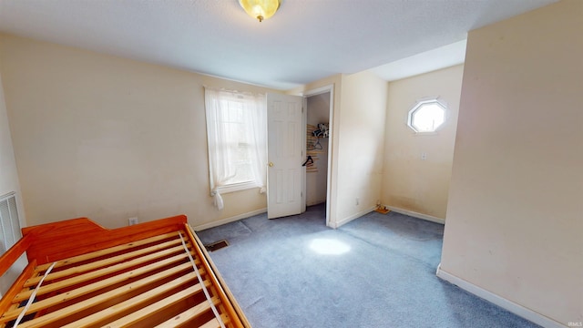 unfurnished bedroom featuring carpet floors, visible vents, and baseboards