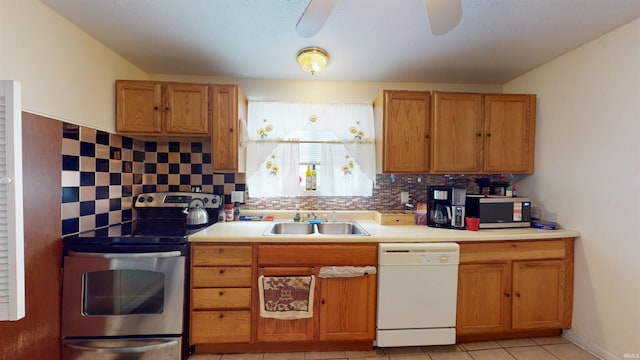 kitchen with electric range, a sink, light countertops, decorative backsplash, and dishwasher