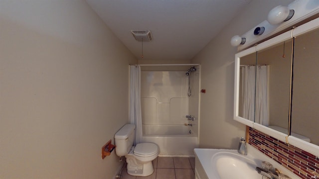 full bathroom with visible vents, toilet, tile patterned flooring, shower / bath combo with shower curtain, and vanity