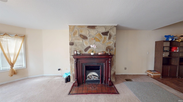 carpeted living room with a large fireplace, baseboards, visible vents, and a textured ceiling