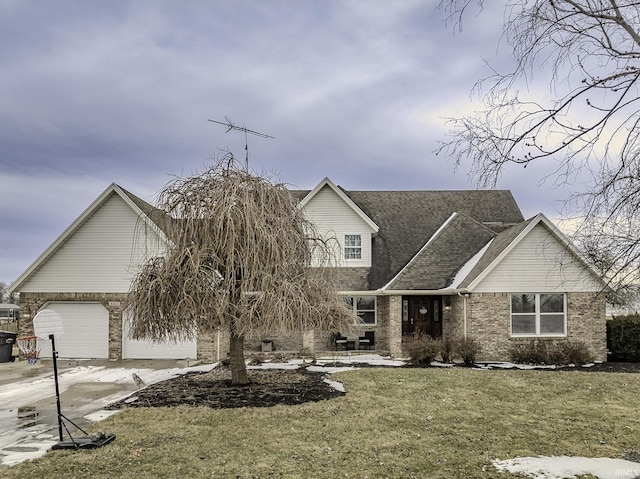 view of front of home featuring an attached garage, brick siding, driveway, and a front yard