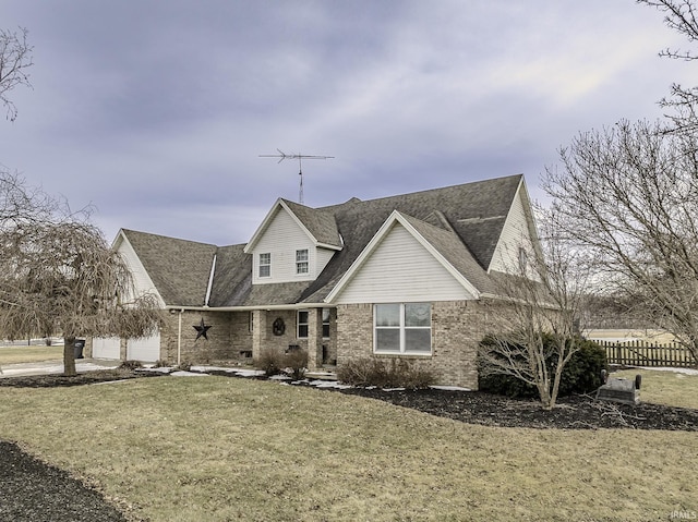 view of front of property featuring an attached garage, brick siding, fence, and a front yard