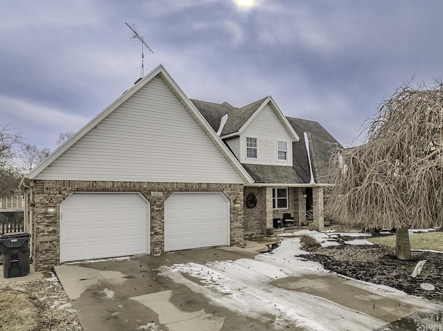 view of front of property featuring a garage, a shingled roof, concrete driveway, and brick siding