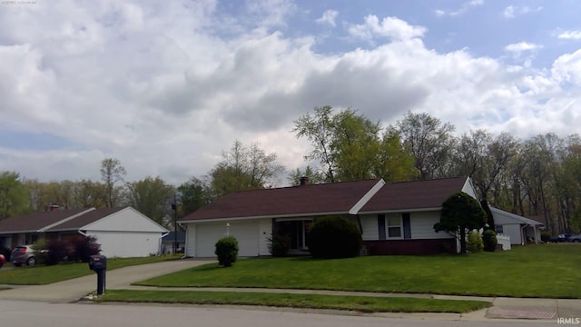 single story home with a garage, concrete driveway, and a front yard