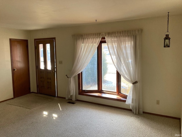 carpeted entryway featuring visible vents and baseboards