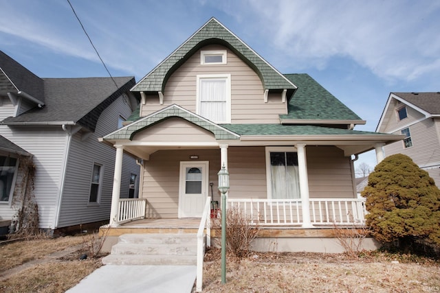 view of front facade featuring a shingled roof and a porch