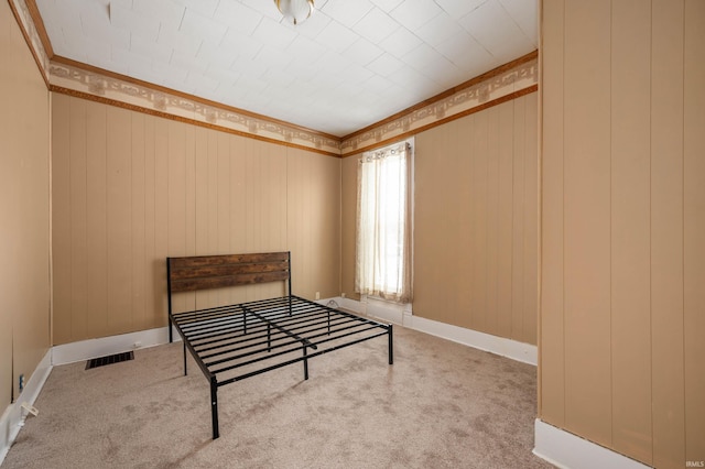 bedroom featuring crown molding, baseboards, visible vents, and light colored carpet