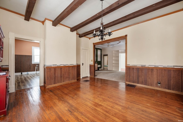 living area with a notable chandelier, wood finished floors, visible vents, wainscoting, and beam ceiling