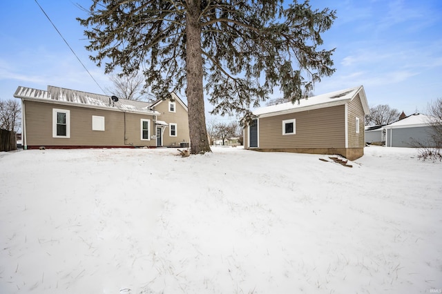 snow covered house featuring a garage