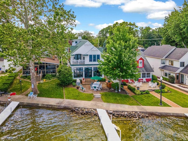 back of house with a water view, a lawn, a patio area, a balcony, and a residential view