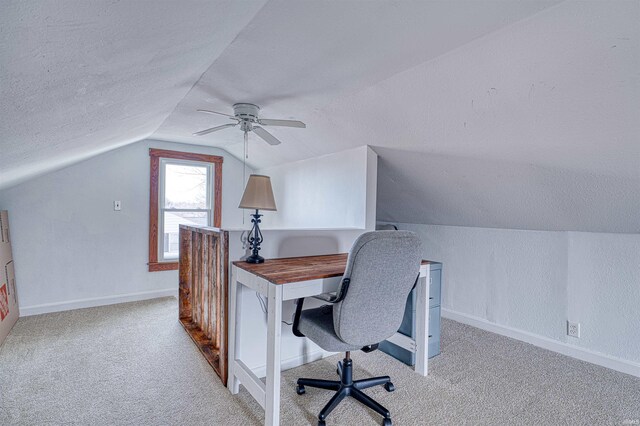 office area featuring baseboards, light colored carpet, ceiling fan, vaulted ceiling, and a textured ceiling