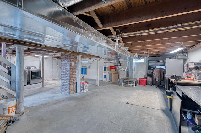 below grade area featuring electric water heater and washer and dryer