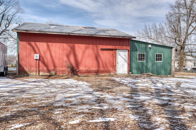 snow covered structure with a pole building and an outdoor structure