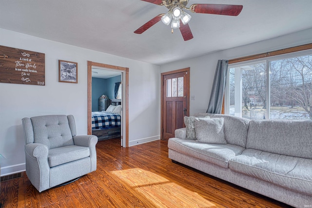 living room featuring visible vents, ceiling fan, baseboards, and wood finished floors